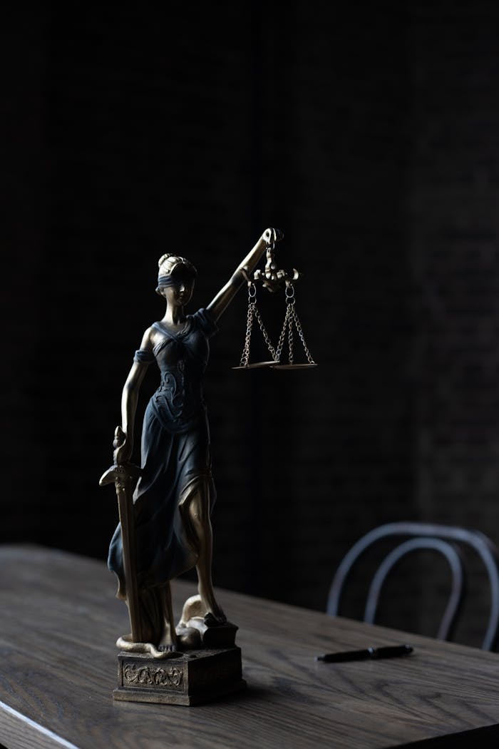 team-04 Dramatic lighting on Lady Justice figurine, symbolizing law and fairness.