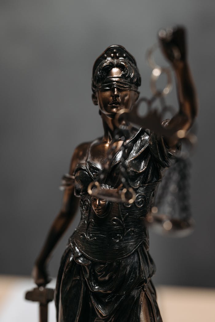 who-we-are Detailed bronze statue of Lady Justice with scales, symbolizing law and justice.